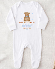 A white onesie with a teddy bear graphic and text that reads "Hand picked by my Brother in Heaven".