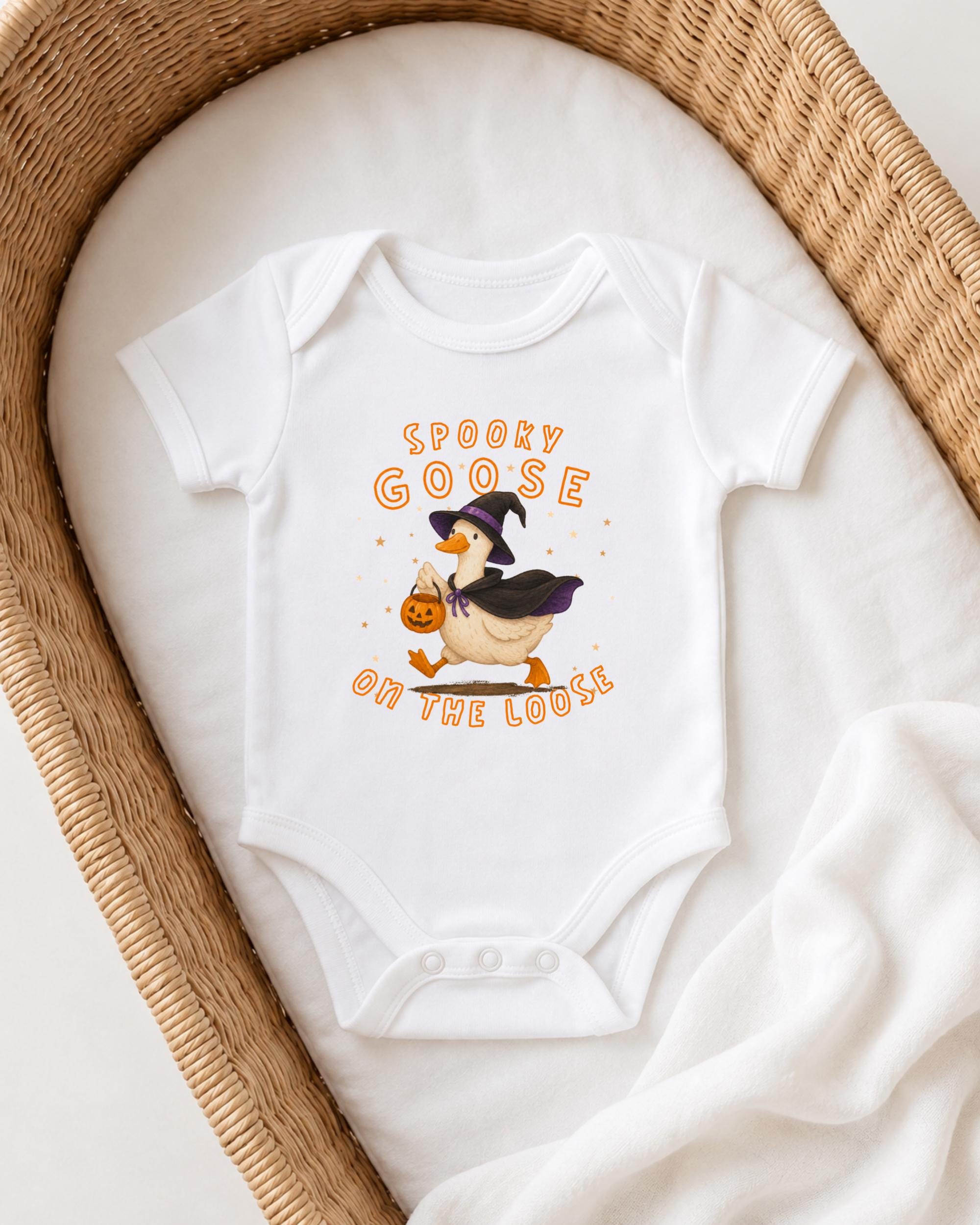 A white baby onesie with a cartoon image of a goose dressed as a witch, along with the text "Spooky GOOSE ON THE LOOSE" printed on it.