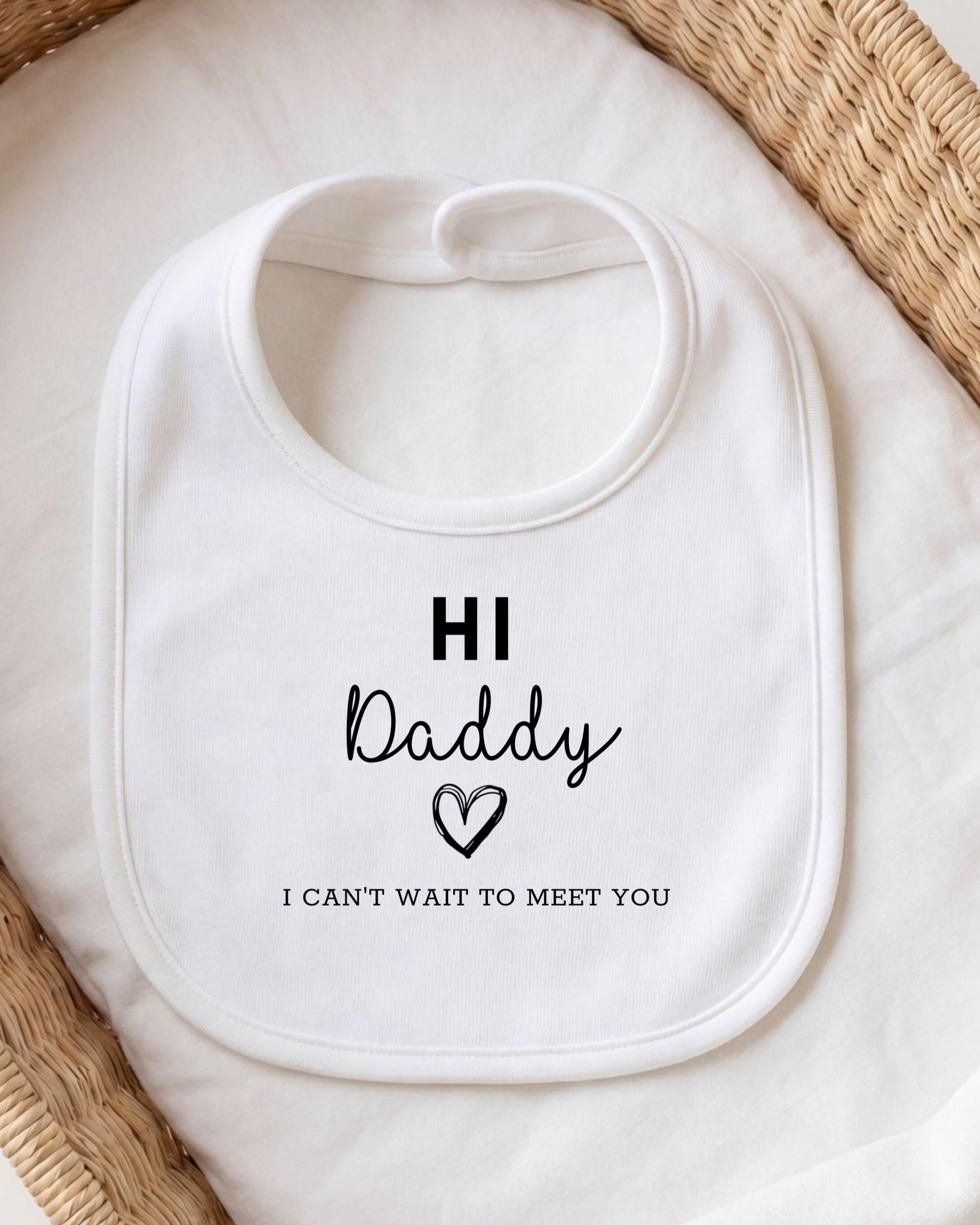 A white bib with the text "HI Daddy I CAN'T WAIT TO MEET YOU" printed on it.