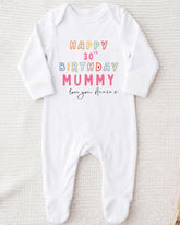 A white onesie with text printed on it, likely a birthday outfit for a baby.