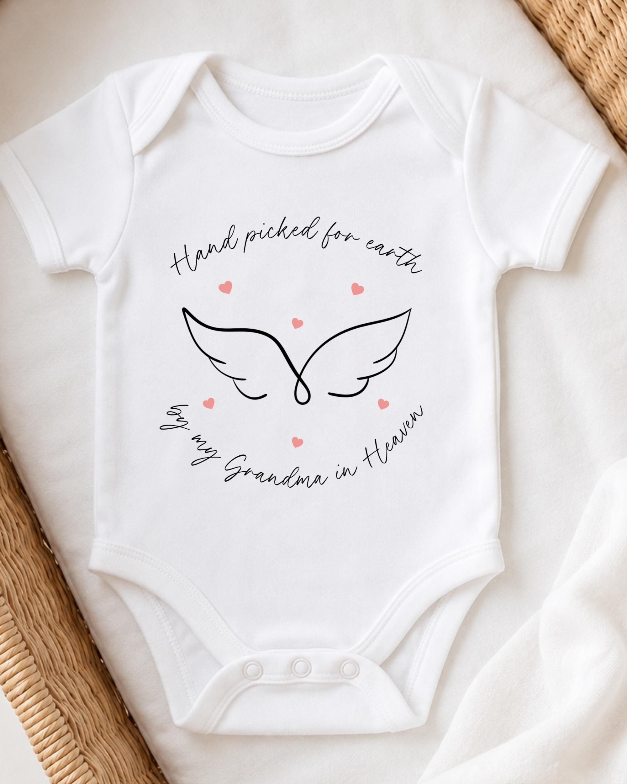 A white baby onesie with a graphic design and text printed on it.