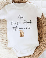 A white baby onesie with a printed message that reads "I love Grandma + Grandpa to the moon & back".