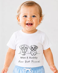 A smiling baby wearing a white t-shirt with a graphic of two dogs and the text "Max & Buddy New Best Friend".