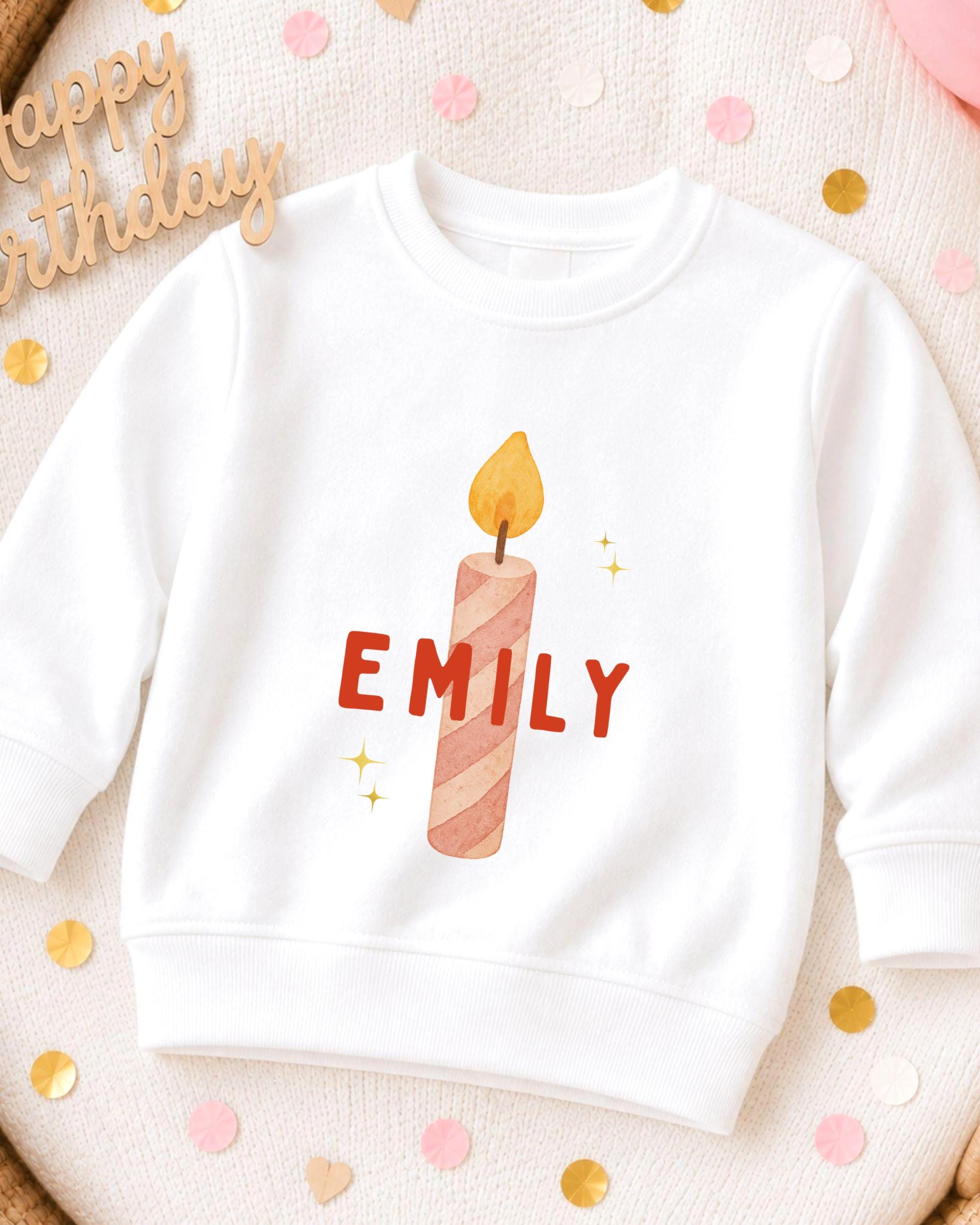 A white sweatshirt with a personalized name printed on it, along with a candle design.