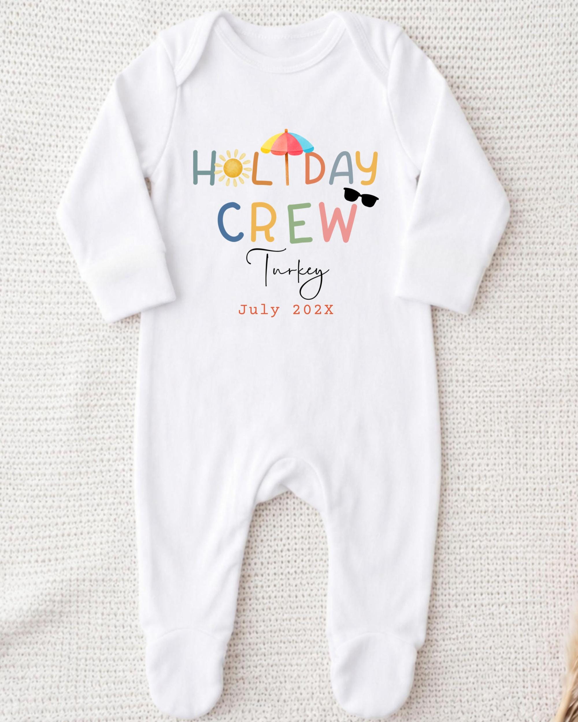 A white onesie with the text "HOLIDAY CREW Turkey July 2023" printed on it.