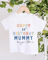 A white t-shirt with a colorful text message that reads "Happy 30th Birthday Mummy love you: Ollie X" printed on it.