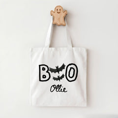A white tote bag with the text "BOO OLLIE" printed on it, along with bats and a ghost-like figure.