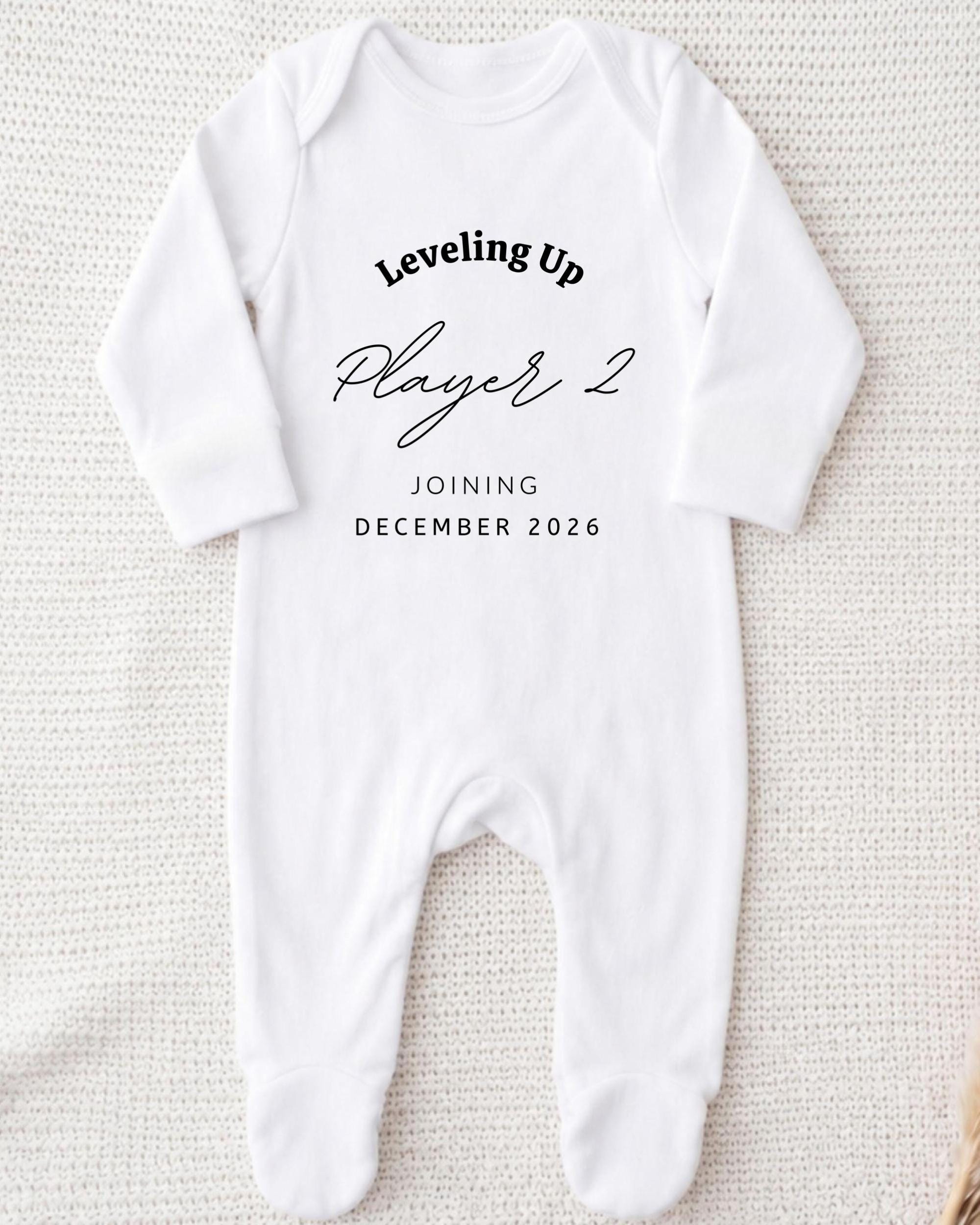 A white onesie with text printed on it, placed on a white background.