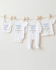 a collection of baby clothes, including onesies and pajamas, hanging on a clothesline.