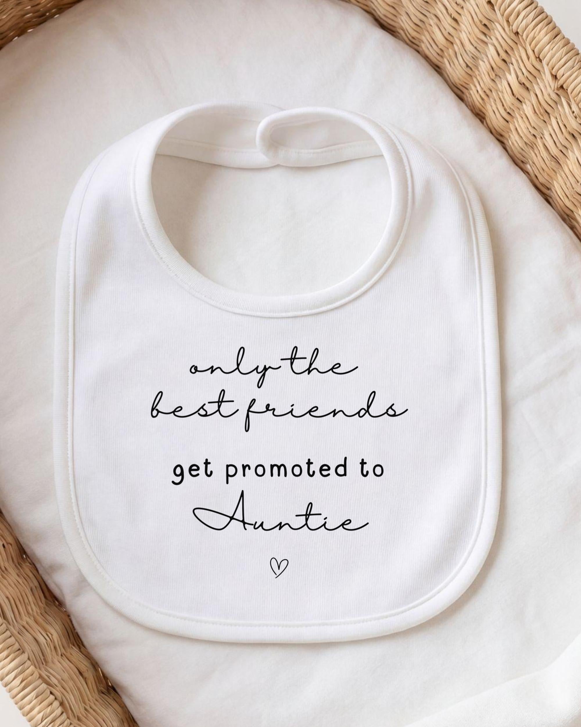 A white bib with black text that reads "only the best friends get promoted to Auntie"