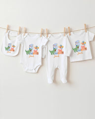 A collection of baby clothes, including onesies and bibs, hanging on a clothesline.