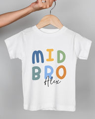 A person's hand is holding a white t-shirt with the text "MID BRO Alex" printed on it.