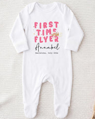 A white onesie with pink text and a small illustration of a bird on it.