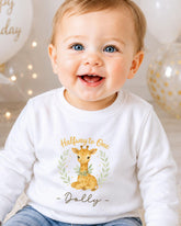 A smiling baby boy wearing a white shirt with a giraffe graphic and the text "Halfway to One - Dolly" printed on it.