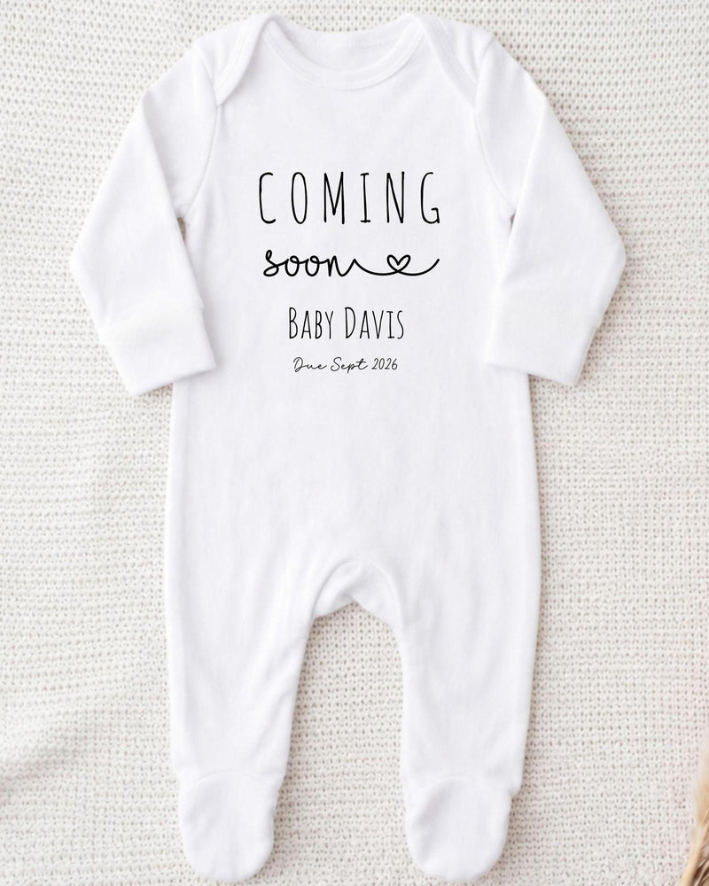 A white bodysuit with the text "COMING soon BABY DAVIS Due Sept 2016" printed on it.
