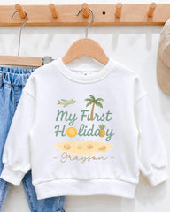 A white sweatshirt with a graphic design and text printed on it, hanging on a wooden hanger.