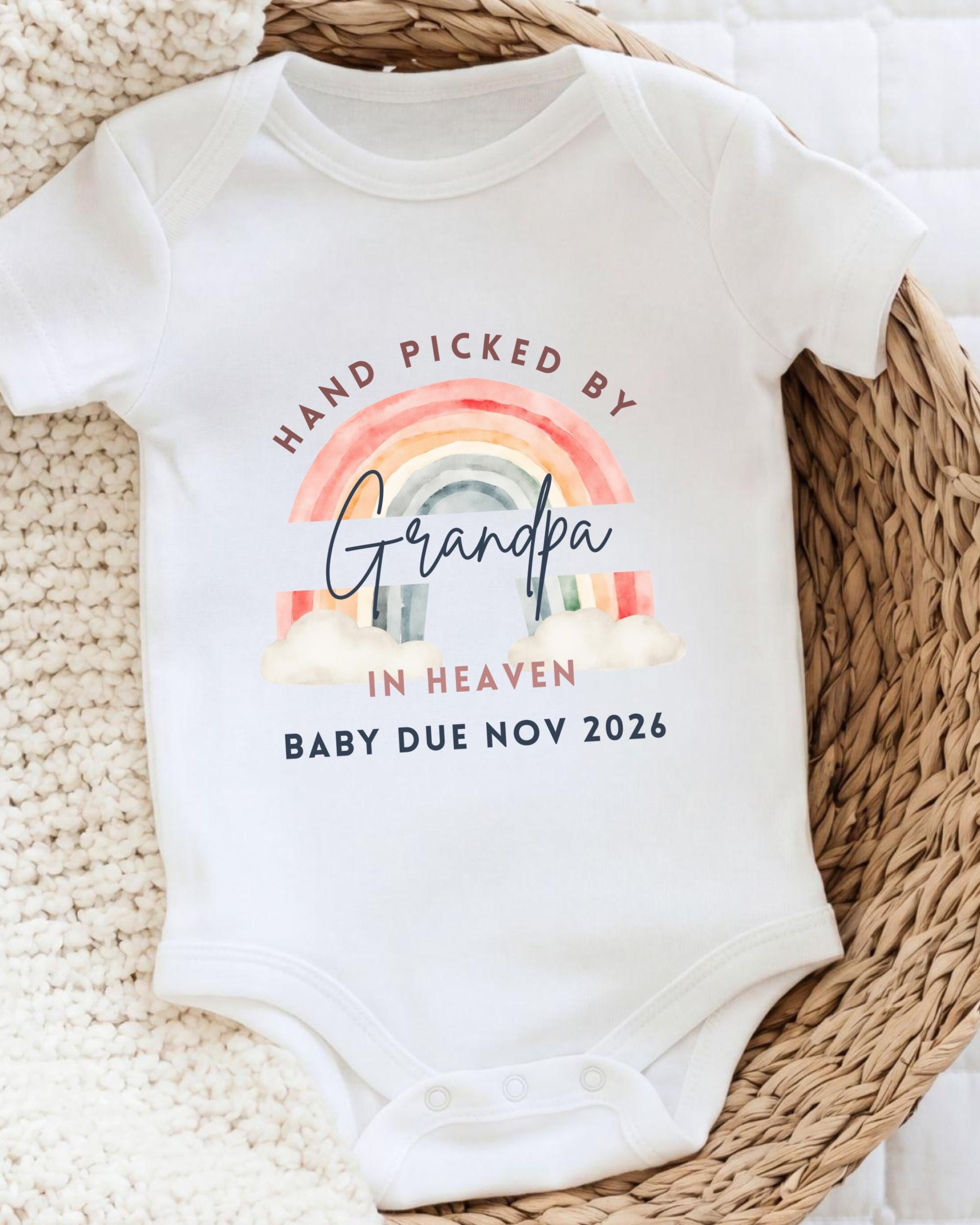 A white baby onesie with a rainbow graphic and text that reads "Hand picked by Grandpa in Heaven Baby due Nov 2026".