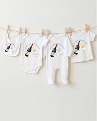 a collection of baby clothes and bibs hanging on a clothesline, with each item featuring a wine bottle graphic.