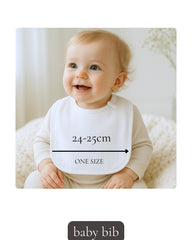 A smiling baby wearing a white bib with measurements and the text "ONE SIZE" is sitting on a white blanket.