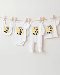 A collection of baby clothes, including onesies and bibs, hanging on a clothesline.