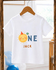 A white t-shirt with a cartoon sun and the text "ONE JACK" printed on it, hanging on a wooden hanger.