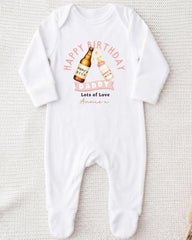 A white onesie with a graphic design on it, featuring a bottle of beer and a baby bottle, along with the text "Happy Birthday Daddy Lots of Love Annie" printed on it.