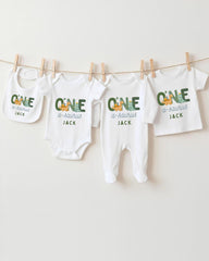 A row of white baby clothes with the name "Jack" printed on them, hanging on a clothesline.