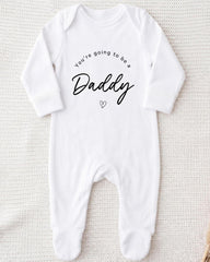 A white onesie with the text "You're going to be a Daddy" printed on it.