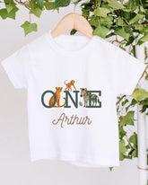 A white t-shirt with a graphic design featuring a monkey, zebra, and leopard, along with the text "ONE Arthur" printed on it.
