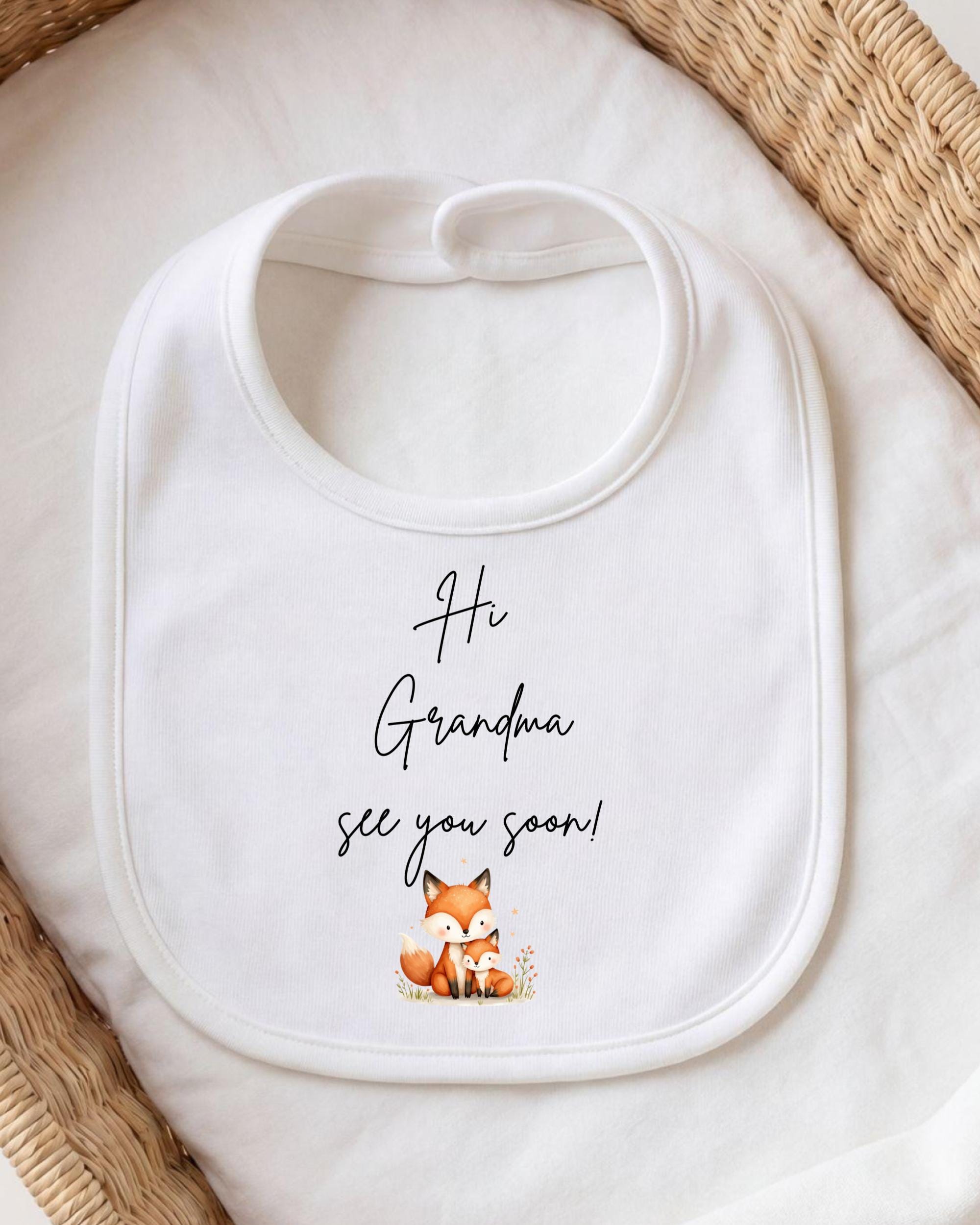 A white bib with a playful message printed on it, placed on a white cloth.