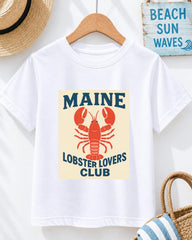 A white t-shirt with a lobster graphic and text, hanging on a wooden hanger.