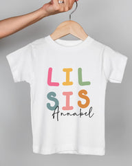 A white t-shirt with the text "LIL SIS Annabel" printed on it.