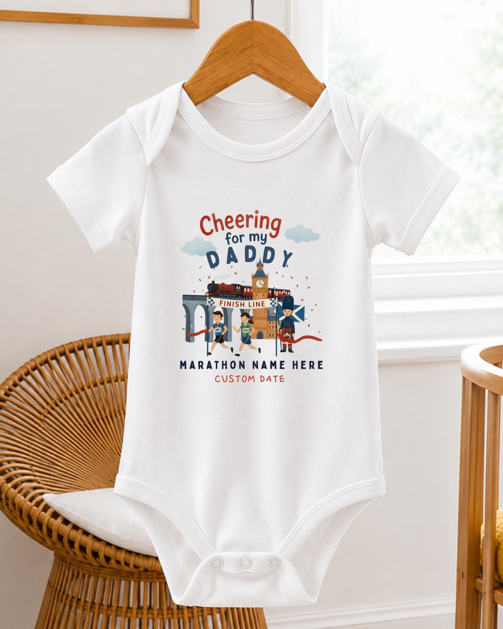 A white baby onesie with a graphic design on it, hanging on a wooden hanger.