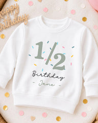 A white sweatshirt with a birthday message printed on it, surrounded by confetti.