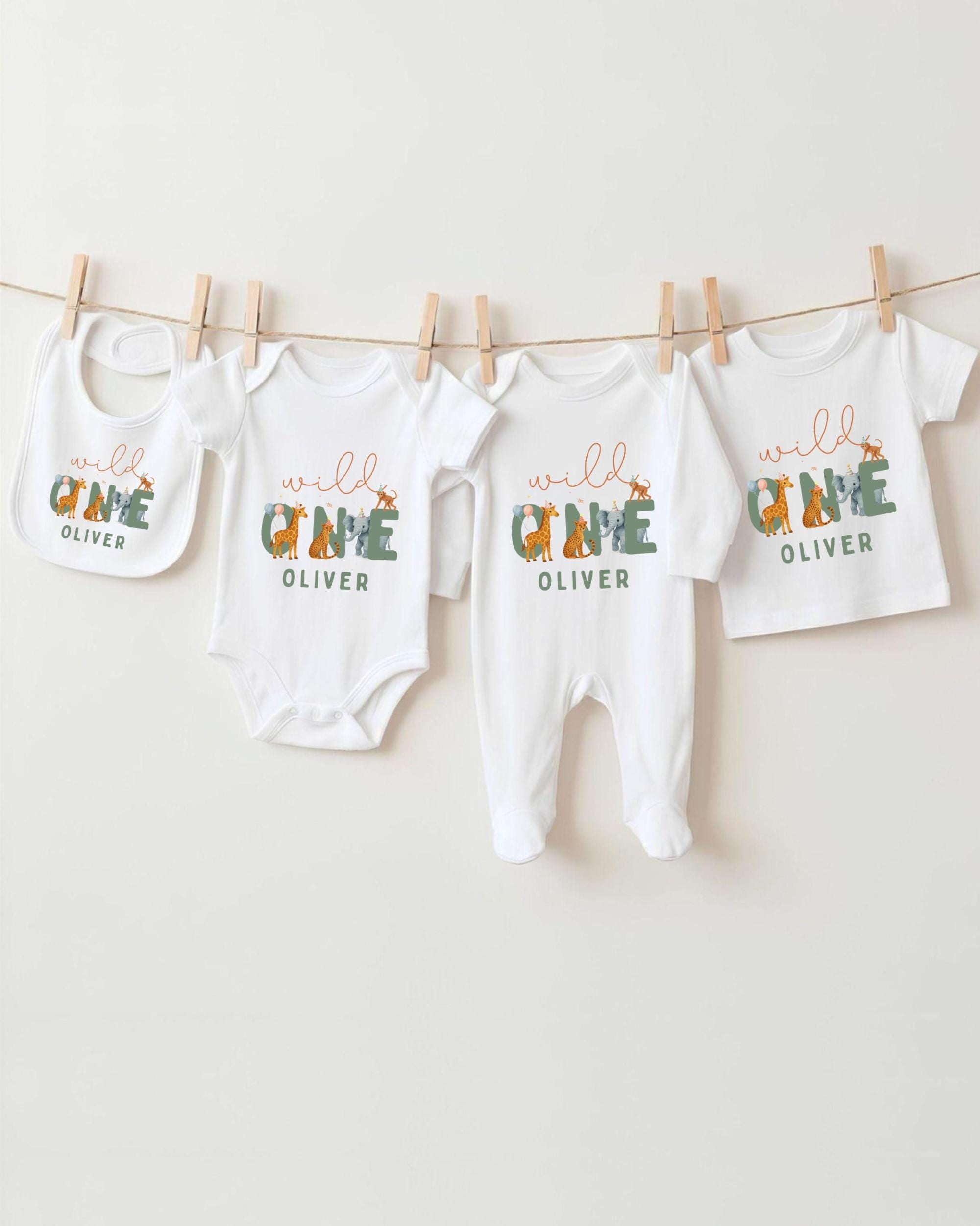 A collection of baby clothes and bibs hanging on a clothesline, with the clothes featuring the name "OLIVER" printed on them.