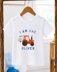 A white t-shirt with a graphic design of a red tractor and the text "I am one Oliver" printed on it.