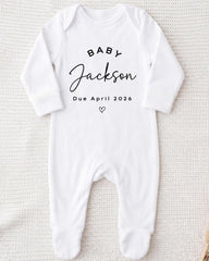 A white onesie with the text "BABY JACKSON Due April 2026" printed on it.
