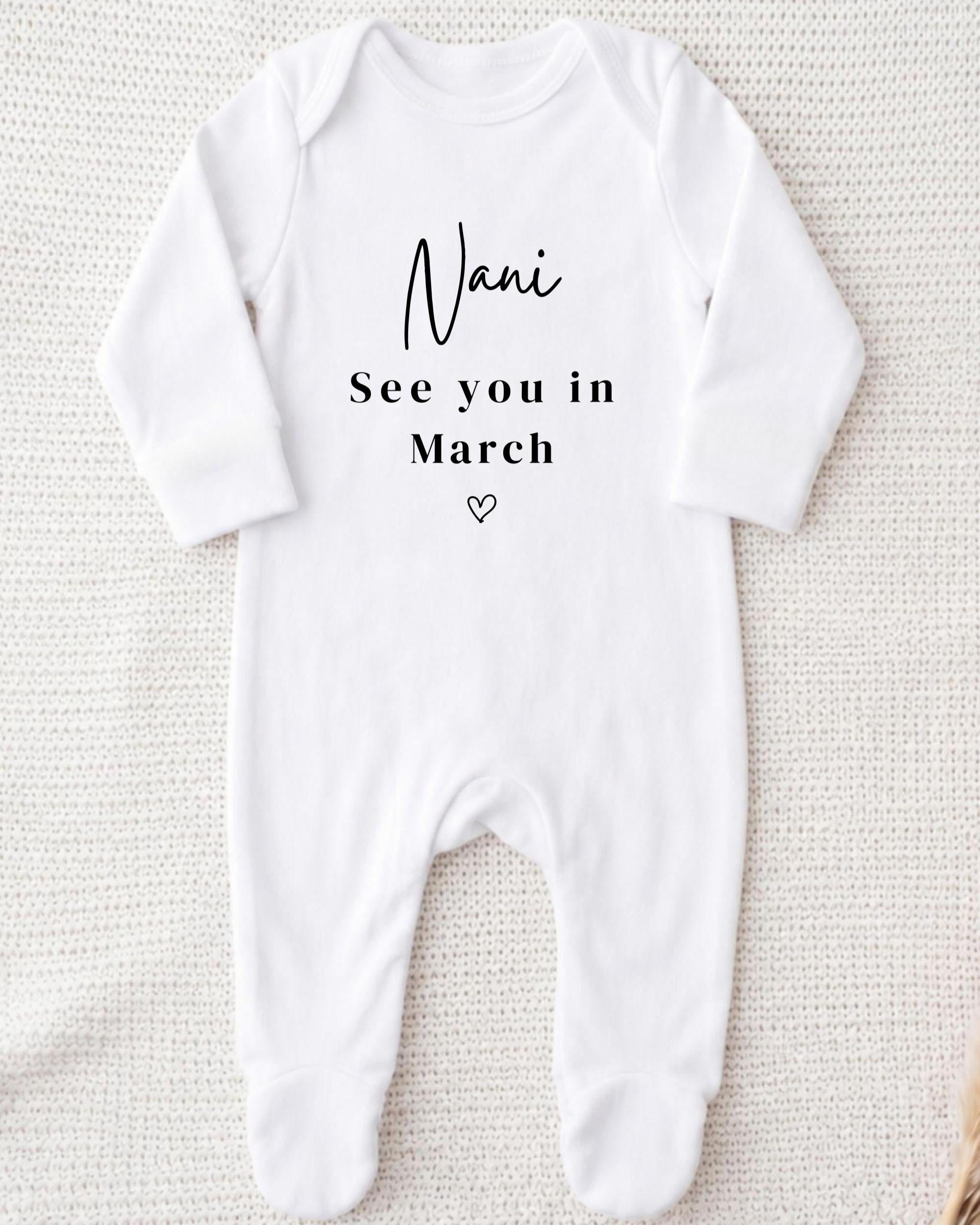 A white onesie with the text "Nani See you in March" printed on it.