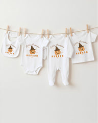 A collection of baby clothes, including onesies and bibs, hanging on a clothesline.