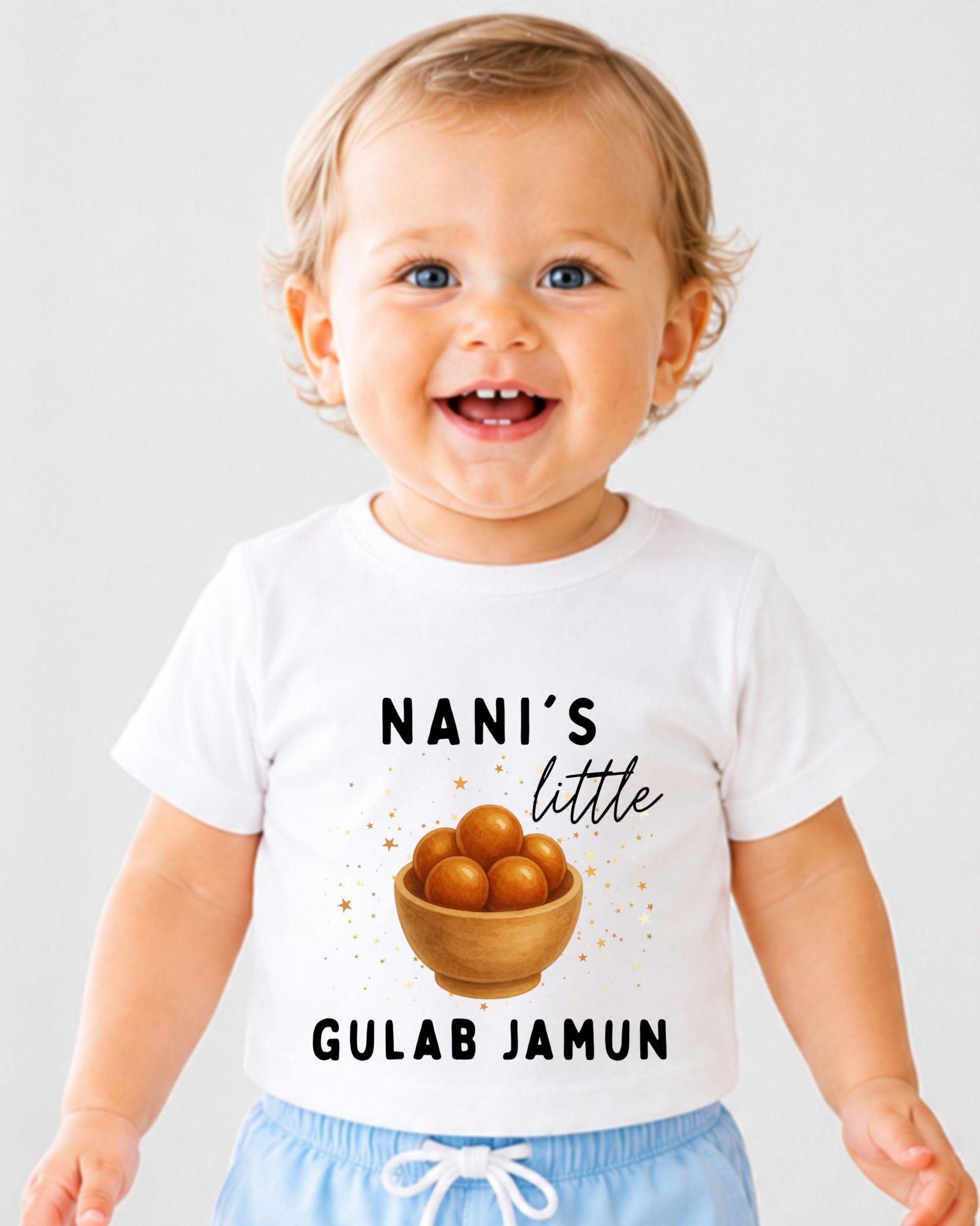 A smiling baby wearing a white t-shirt with a graphic design and text.