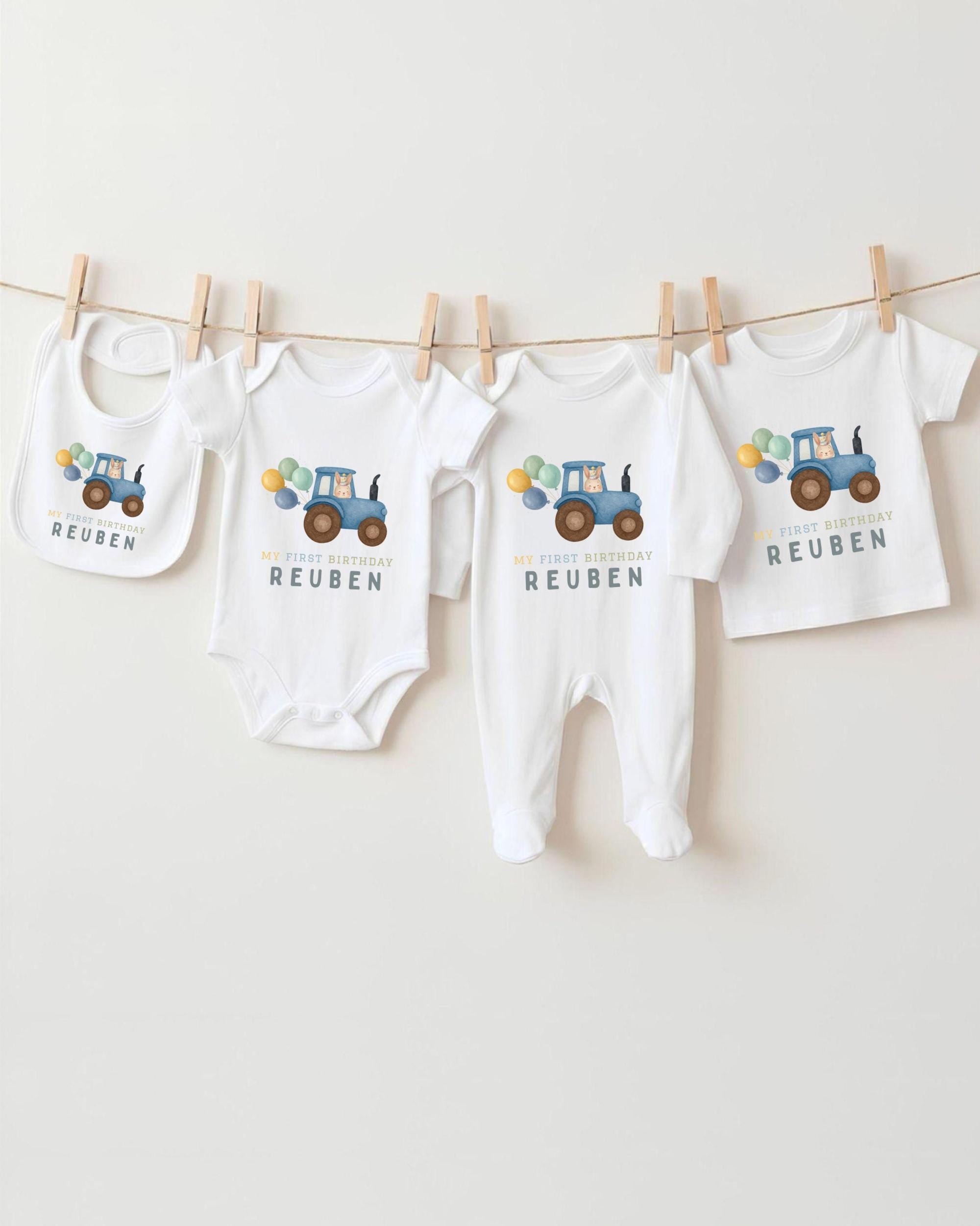 A collection of baby clothes, including onesies and bibs, hanging on a clothesline.