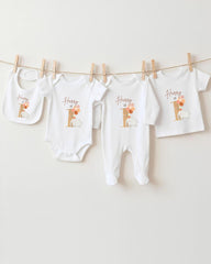 A collection of white baby clothes, including onesies and bibs, hanging on a clothesline.