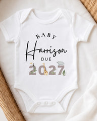 A white baby onesie with text and illustrations printed on it.