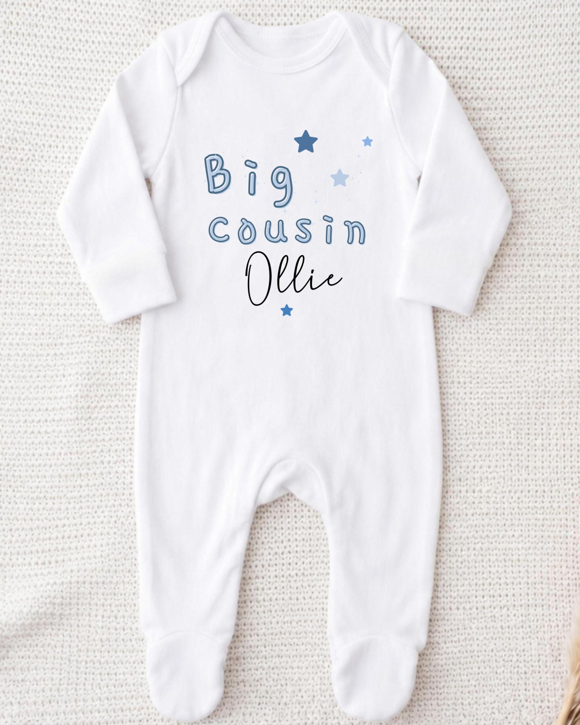 A white onesie with blue text and stars printed on it.