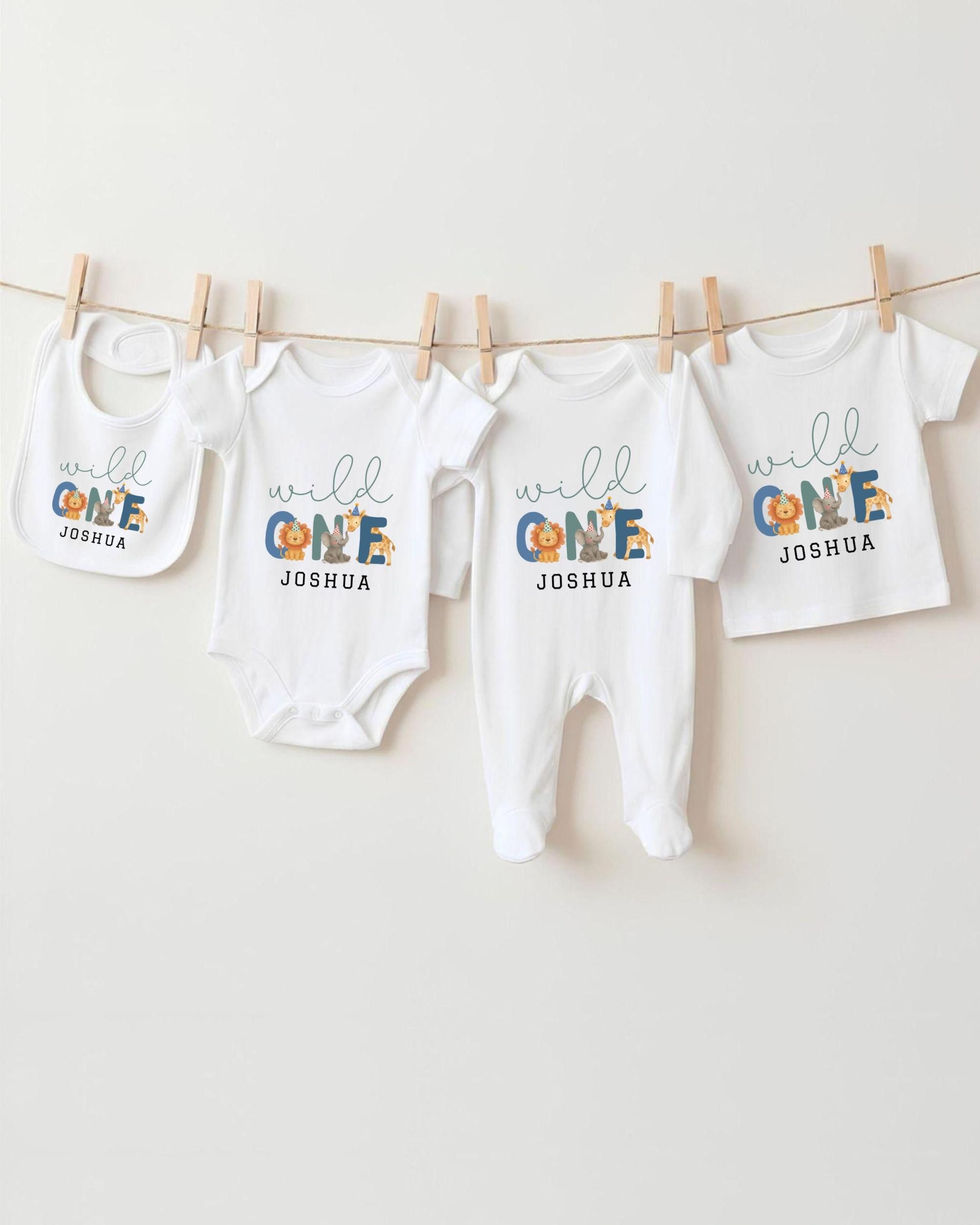 A collection of white baby clothes, including onesies and bibs, hanging on a clothesline.