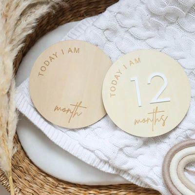 two personalized wooden tags sitting on top of a basket