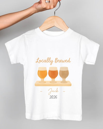 A white t-shirt with a graphic design featuring three beer glasses and the text "Locally Brewed Jack 2026".