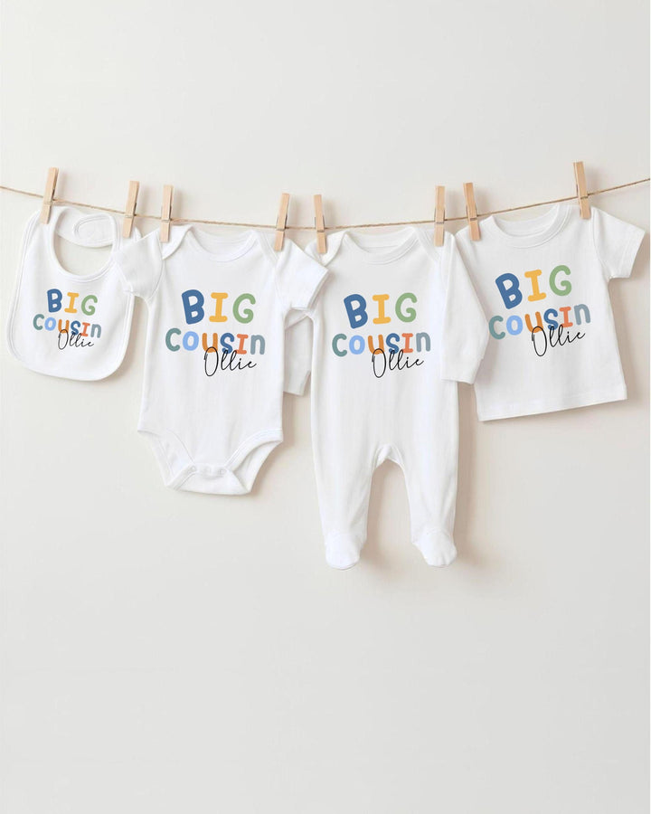 A collection of baby clothes, including bodysuits and bibs, hanging on a clothesline.