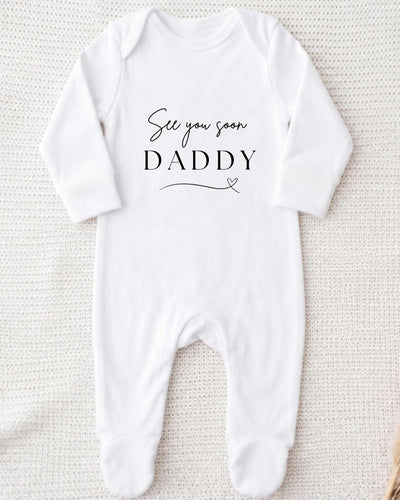 White Baby Grow with black 'See you soon Daddy' script and large serif lettering above a fine heart-shaped flourish.