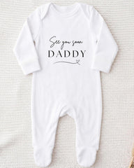 A white onesie with the text "See you soon Daddy" printed on it.